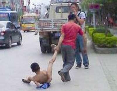 والد صيني يعري ابنه المراهق ويجرجره في الشارع